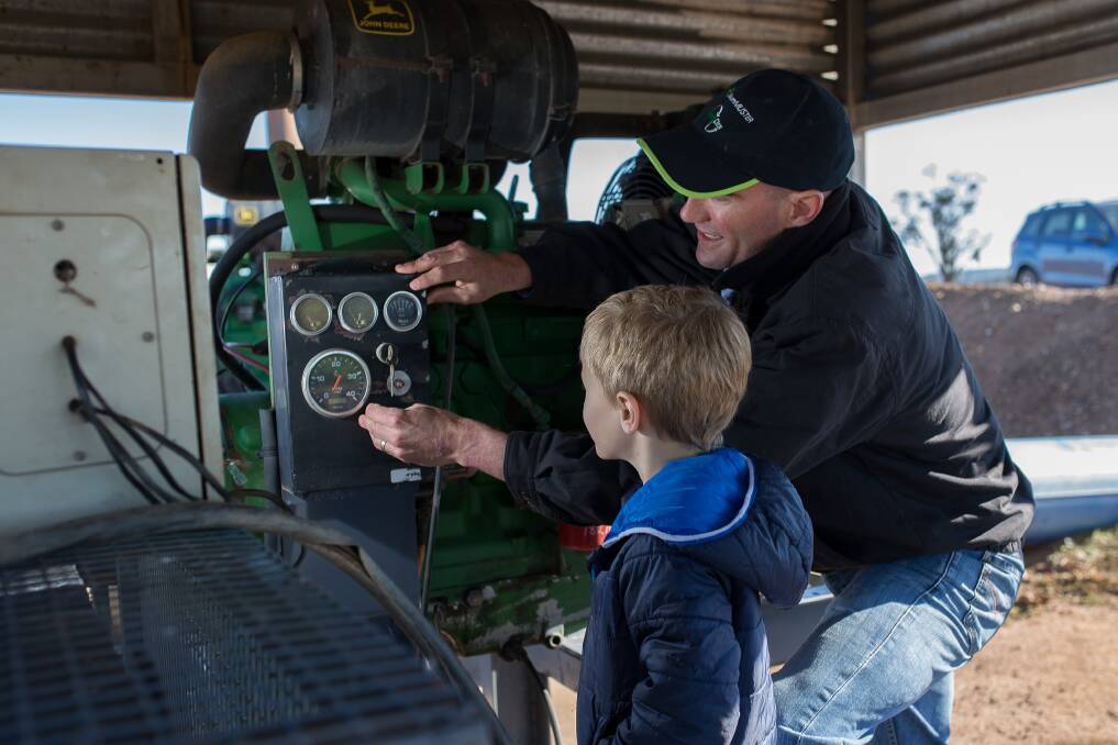 Machinery check: Ryan helping his dad Brendon Warnock look at pressure gauges on one of the water pumps on a bore.