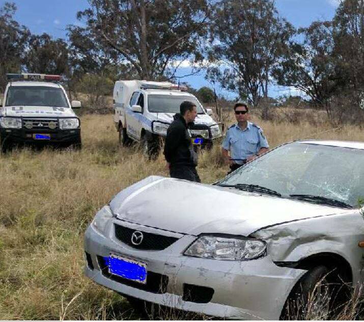 Crash: Police in the paddock where Tucker was arrested. Photo: NSW Police