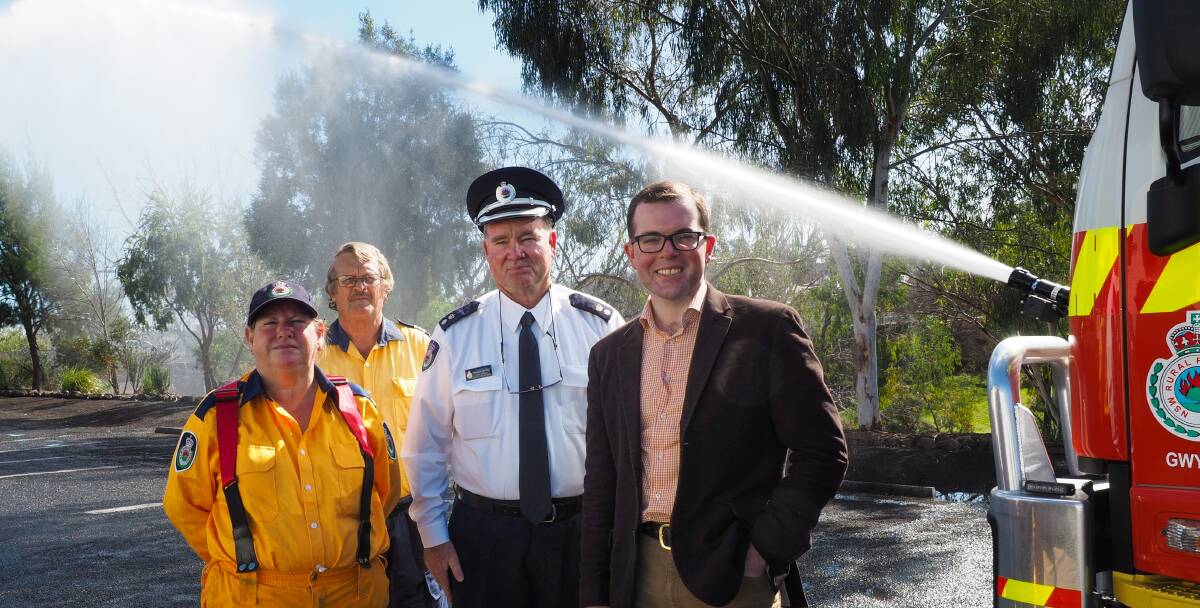 DEMONSTRATION: The water cannon on front of Warialda’s new CAT 6 tanker in action behind Warialda RFS member Gail McKee, Captain Bill Farrar, Namoi-Gwydir RFS Superintendent Michael Brooks and Member for Northern Tablelands Adam Marshall.