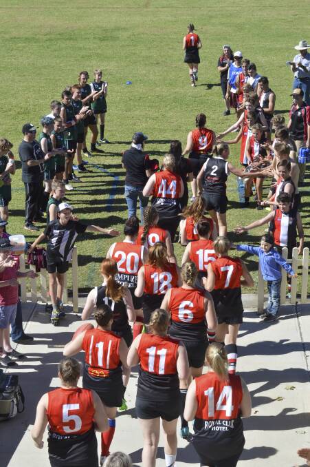 DEBUT: The Inverell Saints run onto the field at Varley Oval on Saturday, surrounded by supporters. Photo: Harold Konz