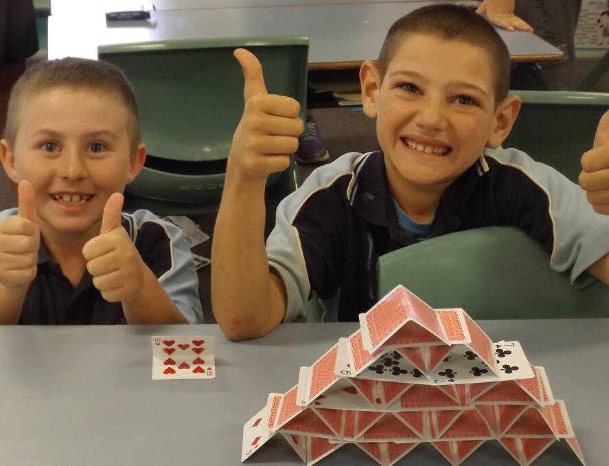 THUMBS UP: Students show their problem-solving skills in a STEM challenge, which are given regularly.