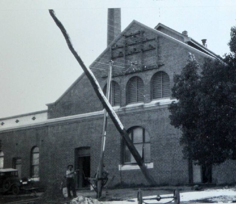 History in action: Power poles being erected in the streets of Inverell.