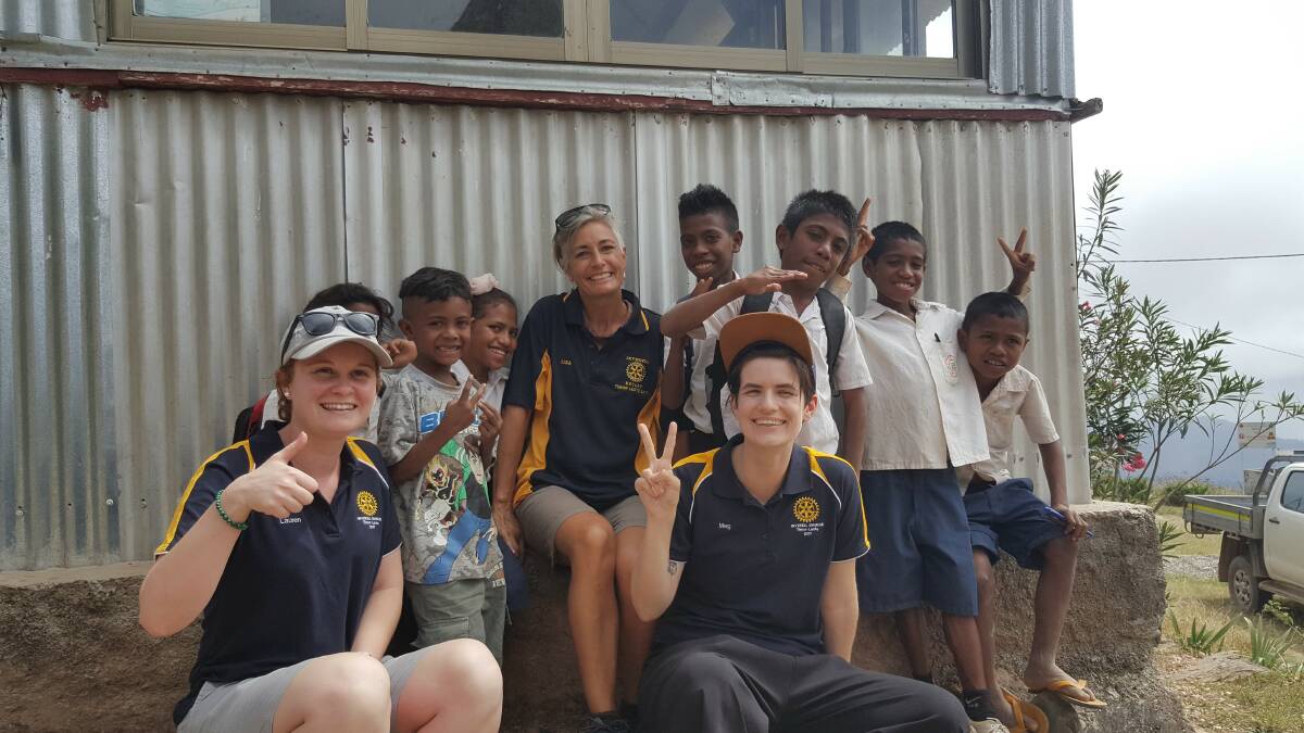 Training trip: Inverell's Lauren Holder, Lisa Longhurst and Mel Hanlon with local children  from the East Timorese village. 