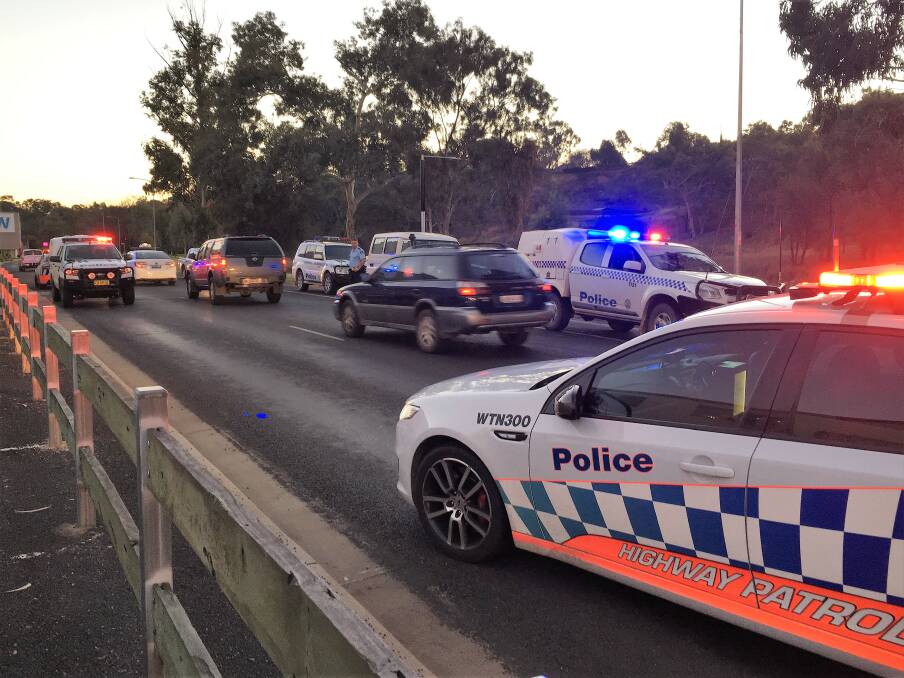 Manhunt ends: Police divert traffic on Captain Cook Dr away from a car park while two were arrested late on Friday afternoon. Photo: Heidi Gibson