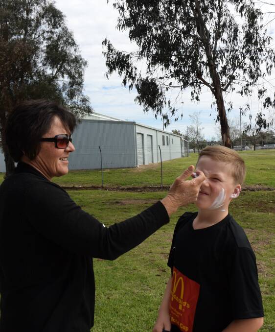 Slip, slap slop: Wallango/Germany's under 11 player Rohan Guest is sun smart with the help of mum, Kim.