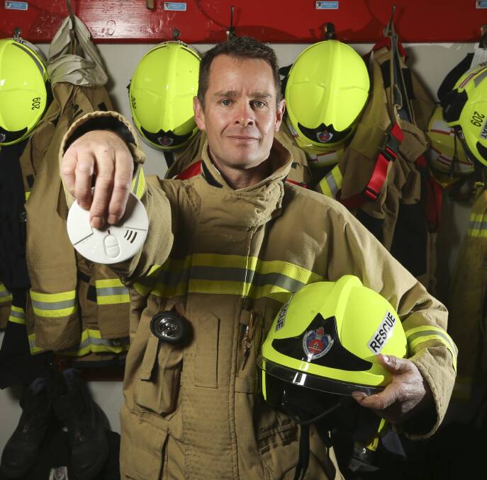 EXPIRED: NSW Fire and Rescue member Paul Bladwell holds a ionisation smoke alarm, recommended to be replaced with photoelectric. Picture: ELENOR TEDENBORG