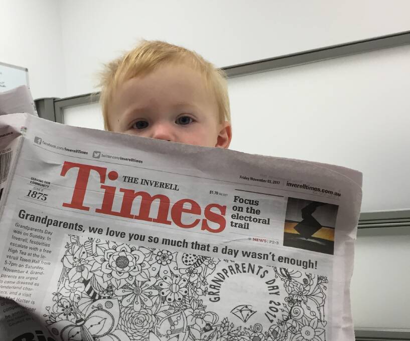 Young Angus Leo Mackay, an avid reader of the Inverell Times, keeps abreast of the latest community events.