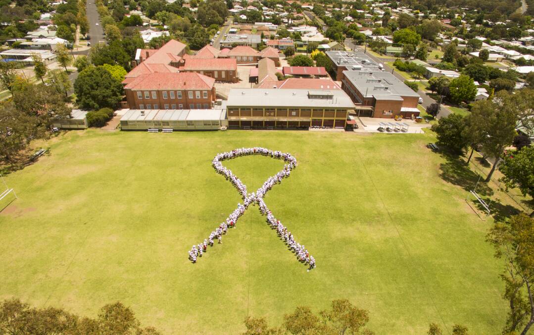 Showing support: The entire school helped form the white ribbon symbol. Photo by Brayden Vickery.