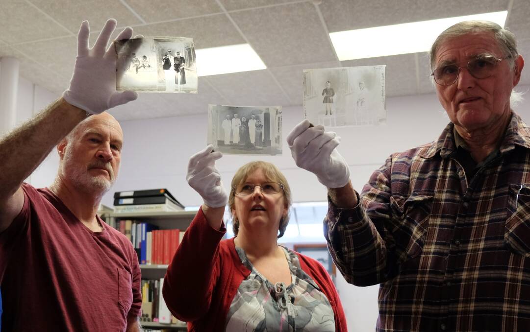 Ken and Kathy McLeod and Merv Hixon with a fragment of the images donated to the history group.