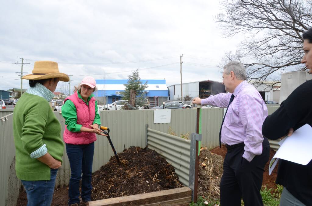 Jane O'Brien shows Mel Farthing, Paul Henry and Abby Hooker the Community Gardens' composting bays.