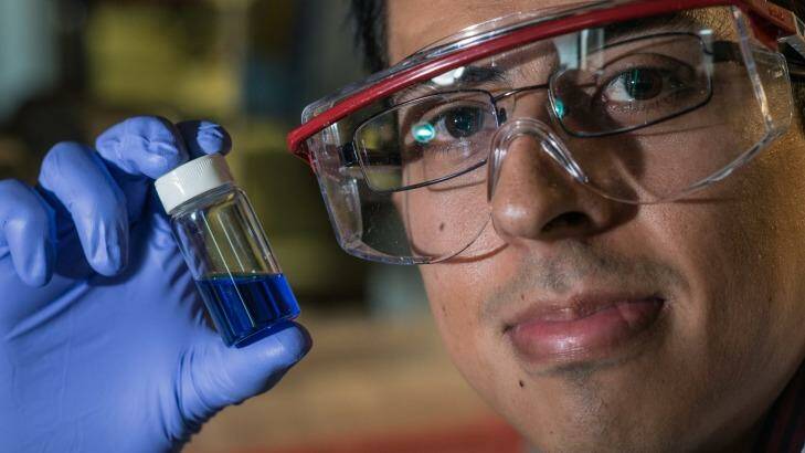 Victor García-López holds a vial with millions of single-molecule nano-subs.
 Photo: Jeff Fitlow, Rice University