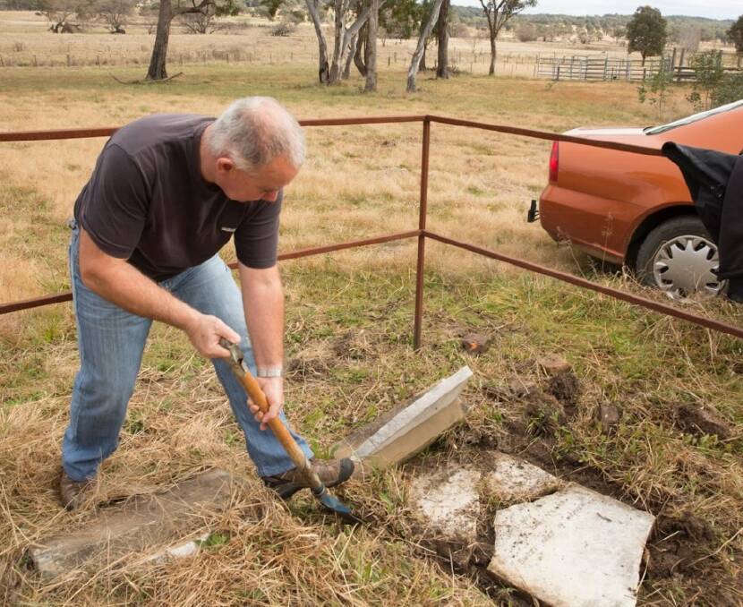 HISTORIC GRAVE: Inverell Reconciliation group member Anthony Dale carefully removes pieces of the headstone for Henry Harrison.    Photo by Rosemary Breen.