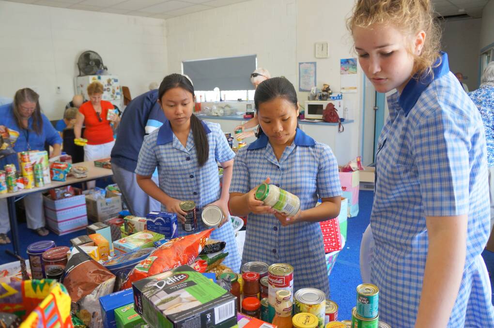 Holy Trinity students, Adrea Enriquez, Fiona Buin and Georgie Fraser sort through some of the food donations.