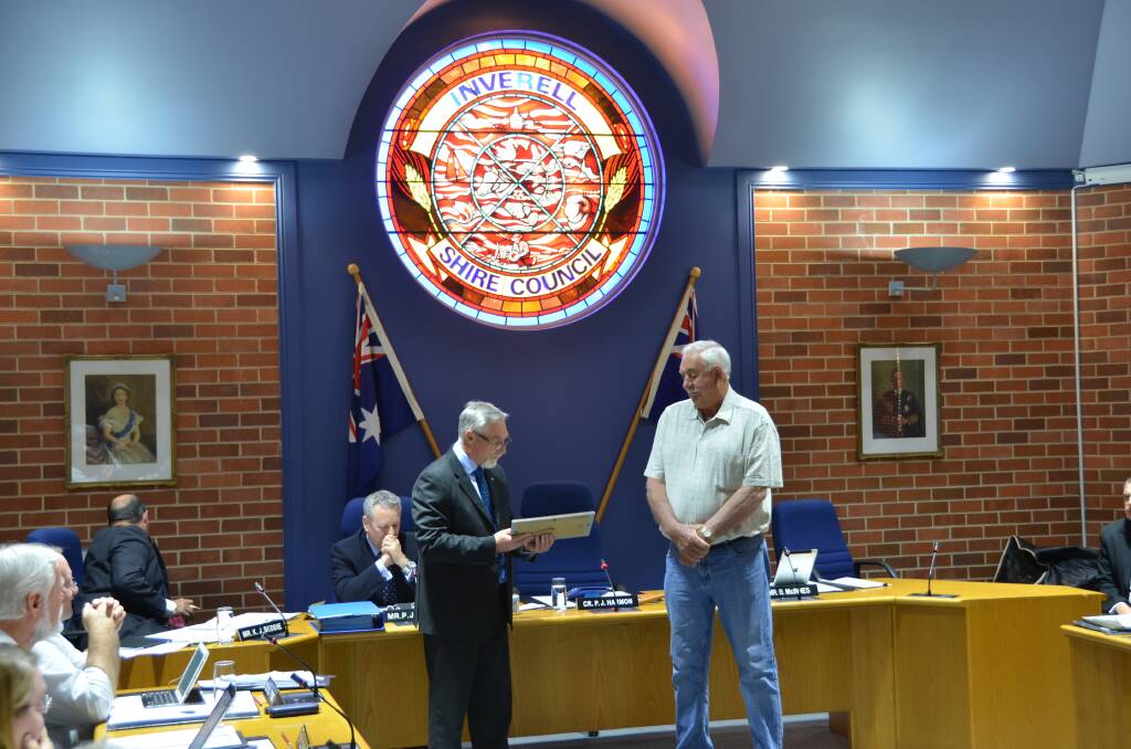 THANKS: Veteran Inverell Shire Council employee John Steiger accepts a gift from Mayor Paul Harmon during last month’s council meeting.