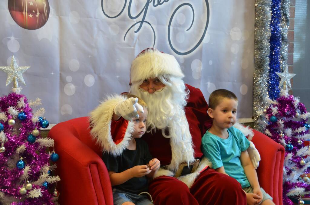 SANTA IS WATCHING: Beau and Riley Alexander get their picture taken with Santa at the Library.