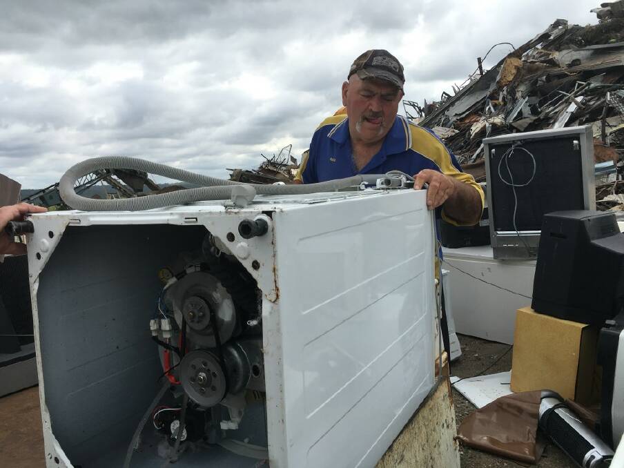 Wayne Mitchell takes care of a washing machine from the trailer.