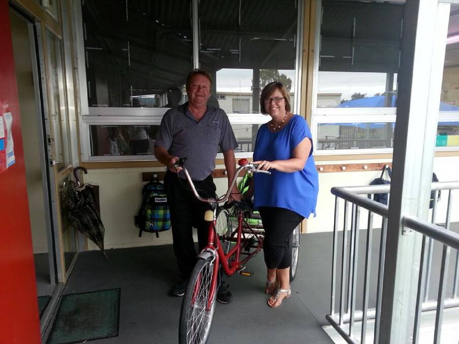 DONATION TO SCHOOL: John Stansfield hands over a tricycle he repaired to Inverell High School’s head teacher support, Karen Ludwig.