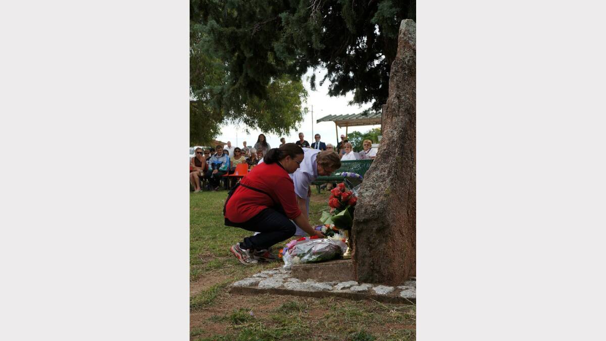 Philippa Raw and Lorna Olgilvie bend to lay the wreath for the Delungra and District Development Council. Pic 69