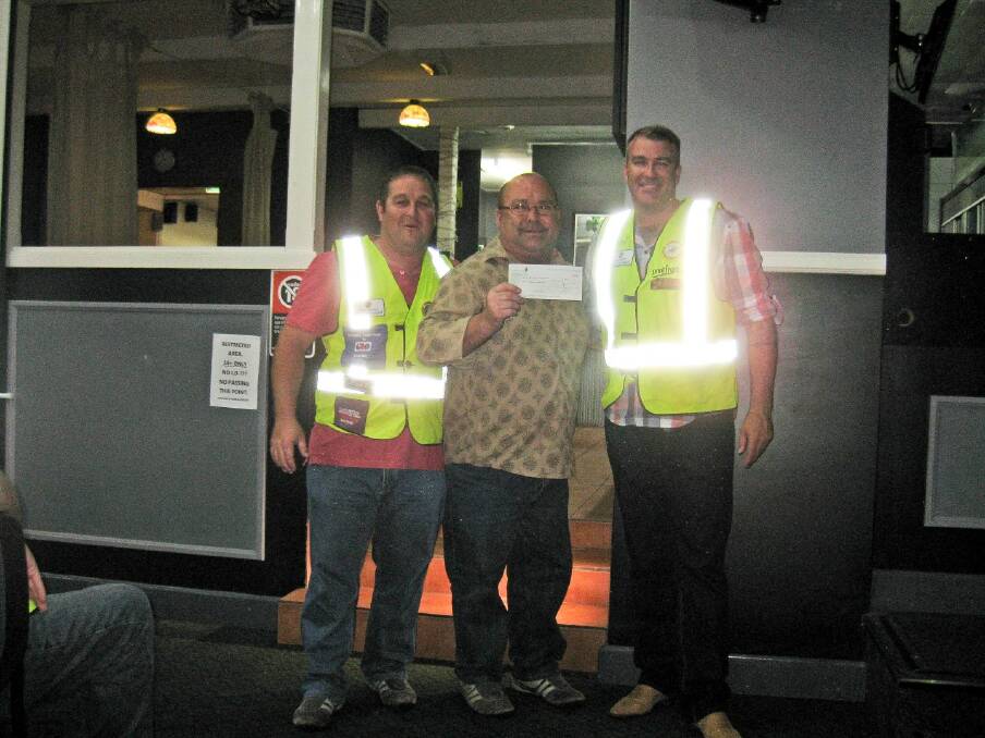 GLOWING: Wearing the reflective vests donned for the Post2Coast Charity ride, event organisers Clint McSpedden and Stuart Griffin flank the Westpac Rescue Helicopter general manager Richard Jones and their gift of $20,000 to the service.