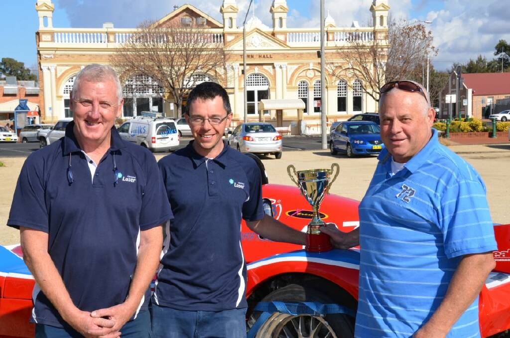 CELEBRATING: Members of the pit crew Pat Alliston and Simon White with Mark Trees and his trophy.
