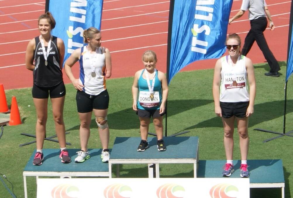 CHAMP: Isabelle Hampton (left) is presented with her bronze medal for javelin in the AWD Australian Athletics Championships.