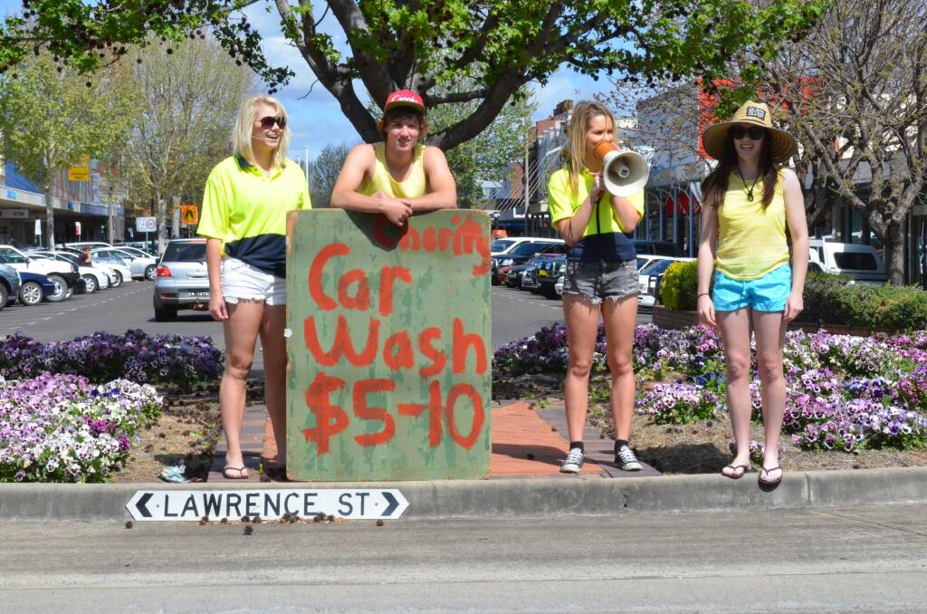 Brittany Walters, Brock George, Ashley Rafter and Izzy Hampton spruik for the carwash on a Byron Street roundabout.