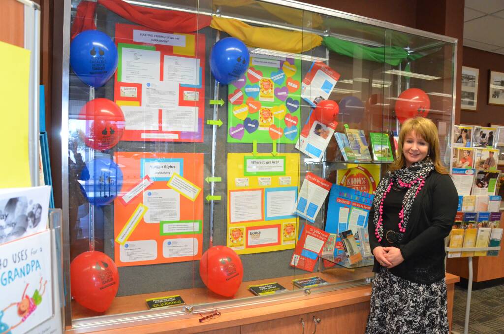 Library service assistant Camille Arca stands with the bullying help display at the lnverell Public Library.