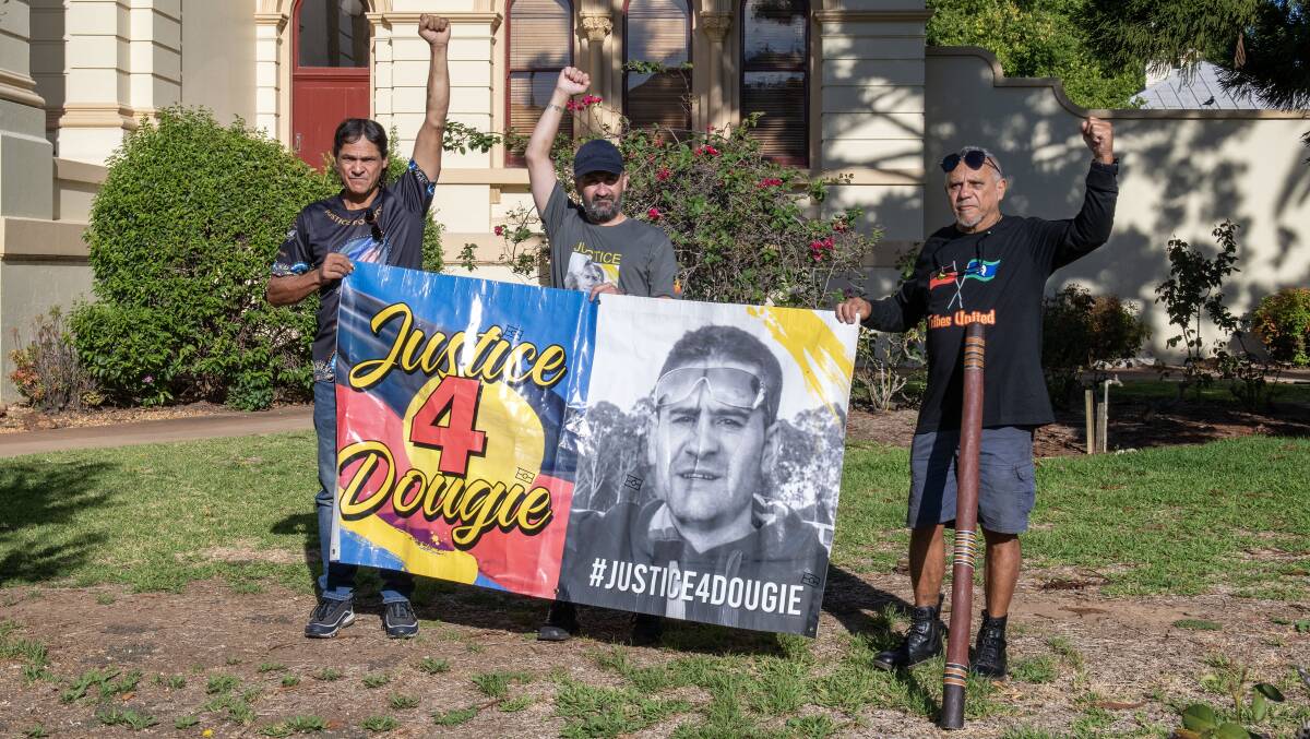 Members of Ricky Hampson Jr's family hold a banner outside the Dubbo court. Picture by Belinda Soole