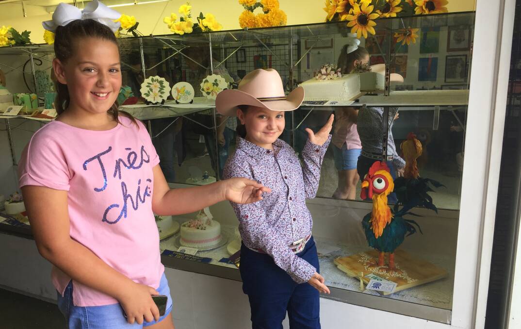 CAKES ON DISPLAY: Michaella and Breanna showcase the rooster cake at the 2018 Inverell Show. There will be so much to do and see at the show and entry is free.