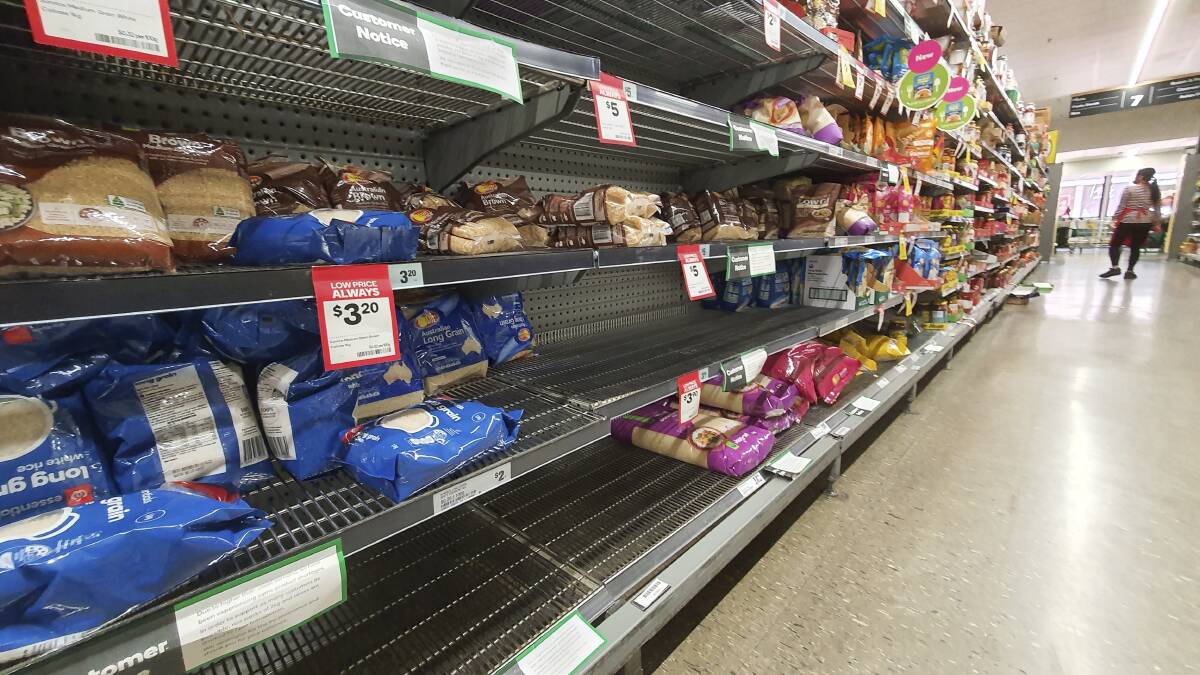 Signs on a Woolworths supermarket shelf in Dickson warn of shortages on products such as rice. Picture: Sitthixay Ditthavong