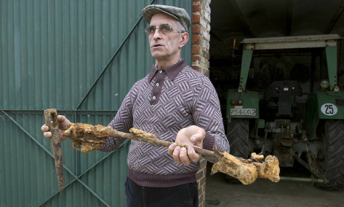 THE ULTIMATE SACRIFICE: French farmer Didier Guerle with a rusted rifle and pickaxe found in his paddock near Bullecourt. 