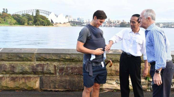President Joko Widodo and Prime Minister Malcolm Turnbull talk to a father carrying his eight-week-old baby. Photo: Indonesian President's Office