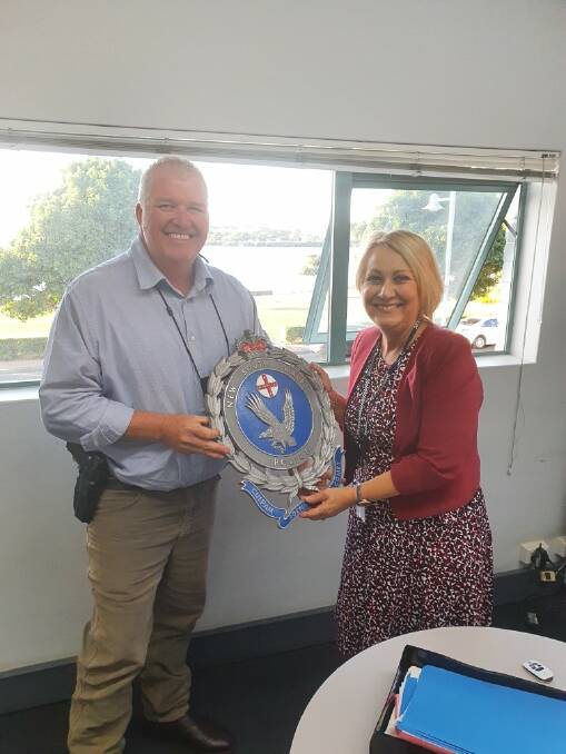 Chief Inspector Rowan OBrien presents Mid North Coast Police District Local Area Manager Roslyn Lang with the crest before it was sent to Lord Howe Island.
