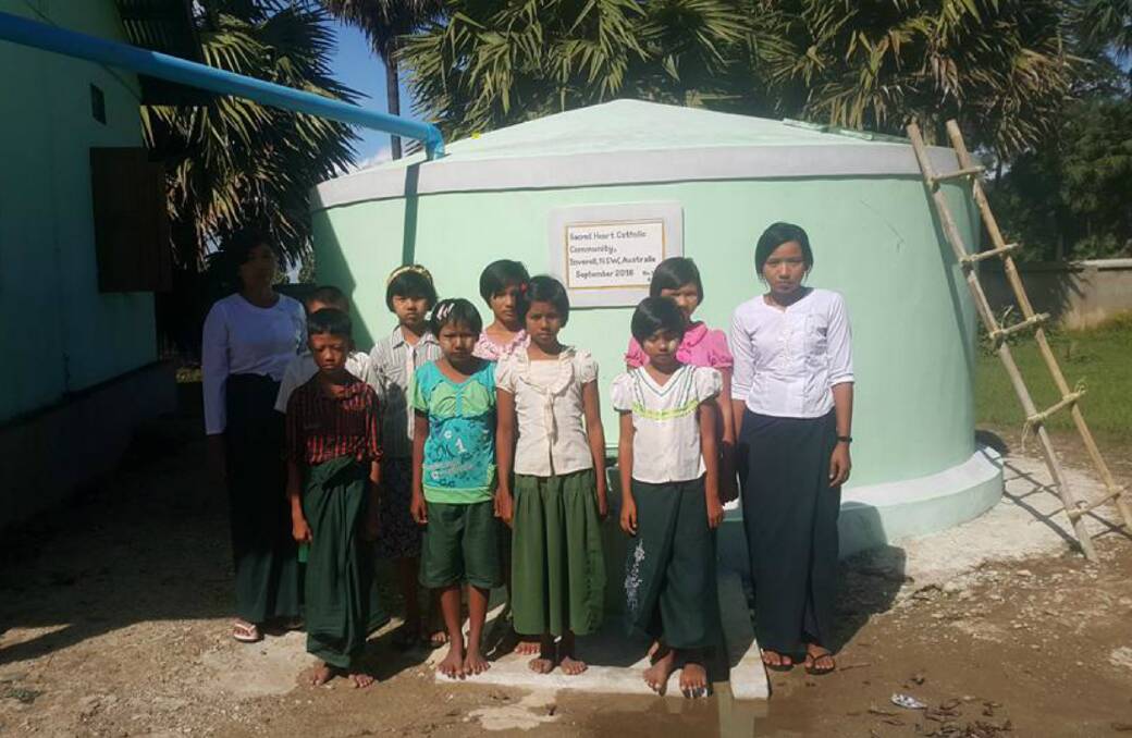 ENERGISED: Shwepyitha village school children beside the new tank, built with funding from the Inverell Sacred Heart Church community. Photo courtesy of Living Water Myanmar