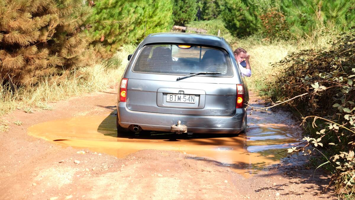 Peter eases his car through one of many deep potholes in the main road in teh Mount Topper forest. 