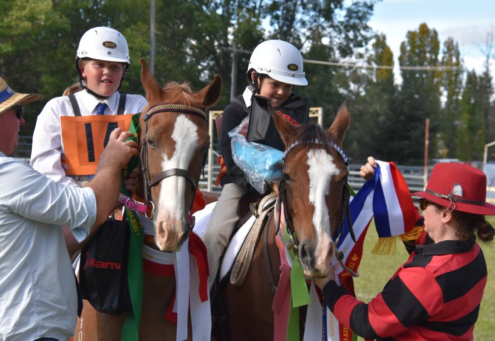 Mackenzie Lyons, pictured left, is awarded the reserve champion sash at the state sporting championships. 
