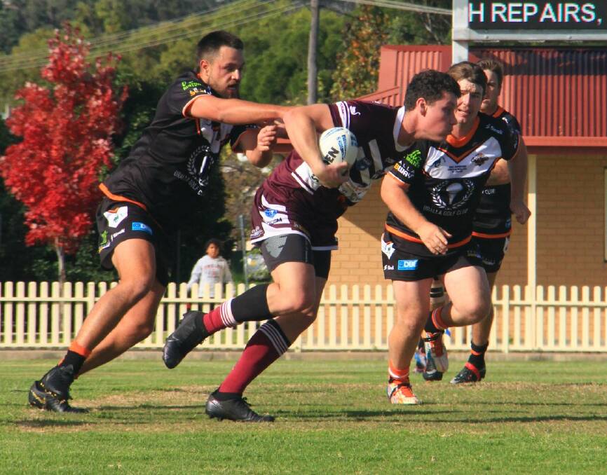 TEARAWAY: The Hawks' Lachie Butler tries to evade the clutches of Walcha's Harley Cox. Photo: Michel Watkins-Milne. 