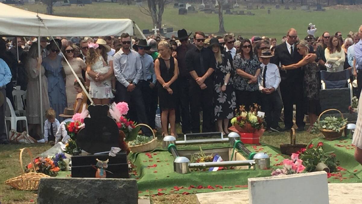 Family and friends at a funeral ceremony held for Robert and Patrick Salway in Cobargo in 2020. 