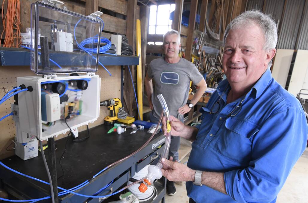 Sandy Gray holds his ventilator prototype in his shed, with Committee for Ballarat chief executive Michael Poulton. Picture: Lachlan Bence