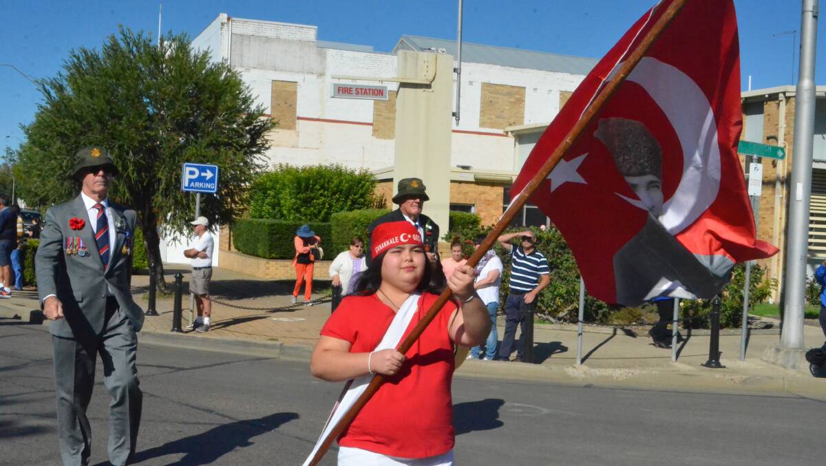 Girl waves Turkish flag with portrait of Ataturk during Anzac Day march 2015.