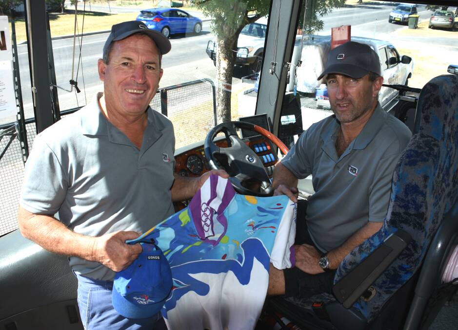 Special opportunity: Rod Hill and Steve Constable drove buses for the Commonwealth Games. Rod still treasures his shirt from working at the Sydney Olympics. 