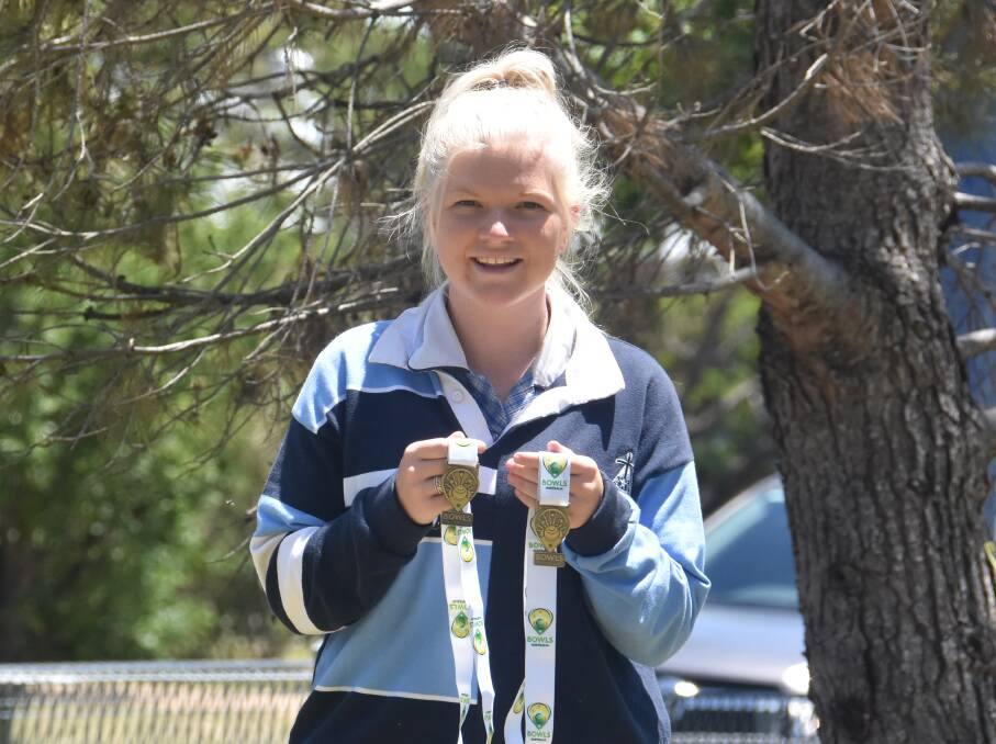 Brittany Camp proudly holds her medals after a successful 2018 bowls season.