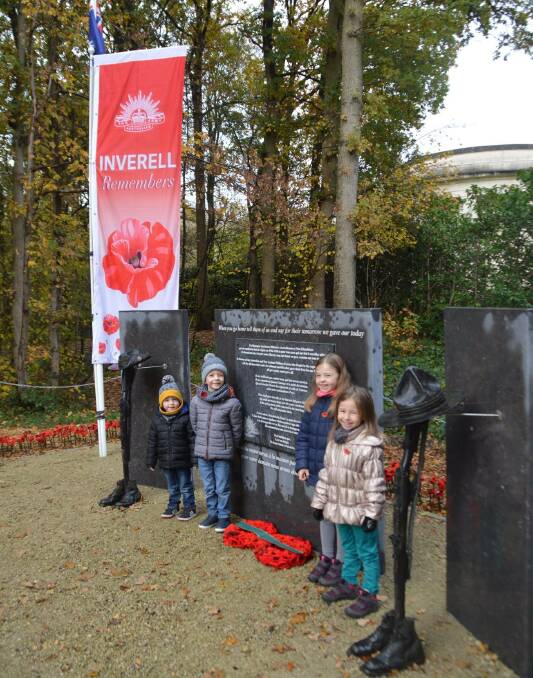 Belgian children stand by the Inverell flag on Remembrance Day. 