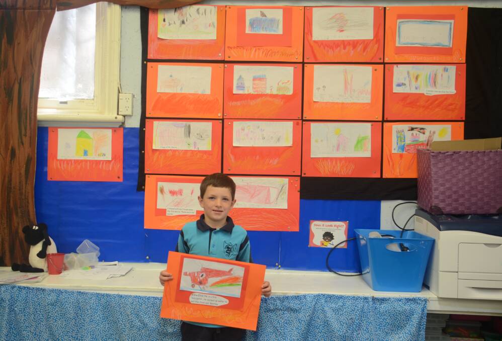 Bentley in year 1 with his drawing of Elvis, the water bombing helicopter, which he saw in action during the fires.