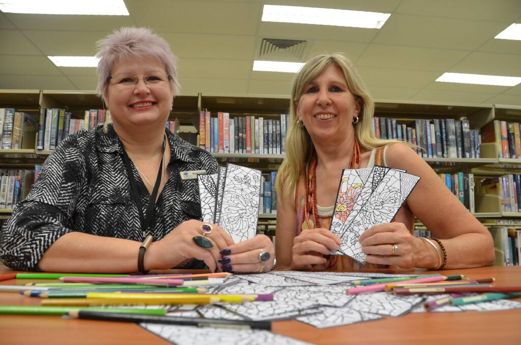 Library manager Sonya Lange and art gallery supervisor Jo Williams display the new bookmarks.