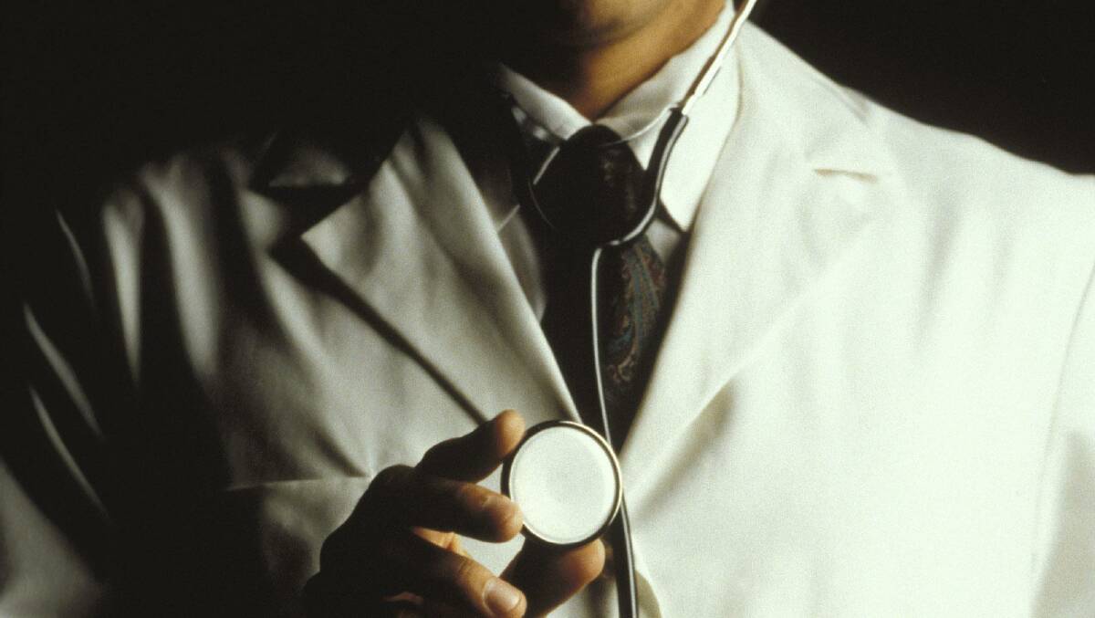 AFP, A doctor in a white lab coat holding up a stethoscope. 