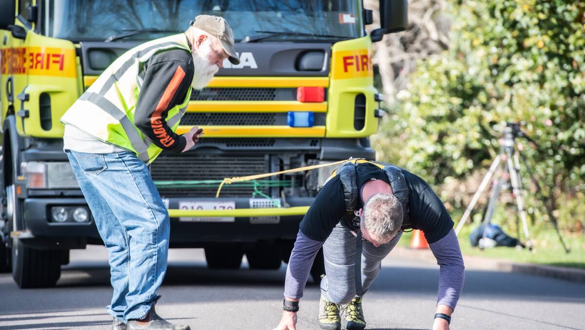 Grant Edwards attempted to pull a 10-tonne fire engine 50 metres to raise awareness for PTSD in our community. Friend David Rugendyke encourages him during attempt. Picture: Karleen Minney