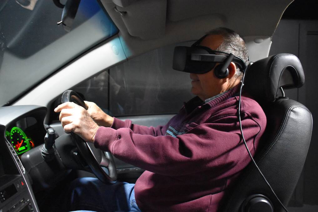 Local volunteer Alan Fuller takes the VR driving simulator 'Hector' for a spin At McLean Care in Inverell.