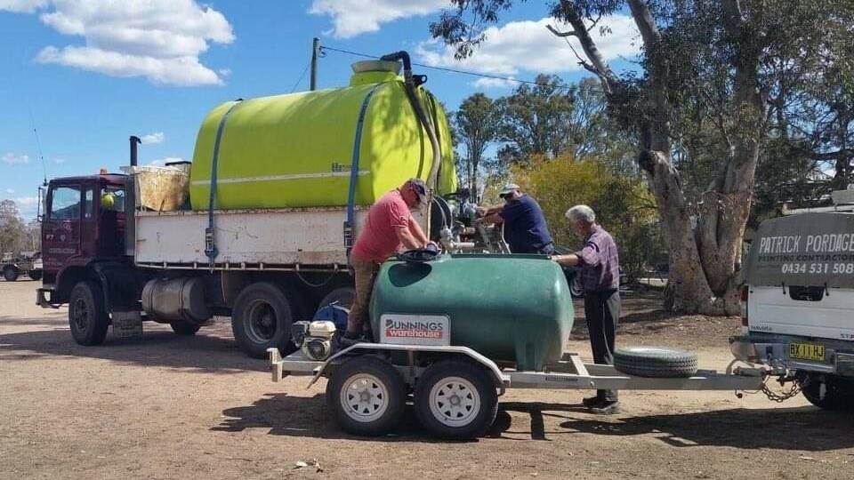 Inverell Apex Club members filling up the Bunnings water tank with Chris Pay's 12,000 litre water truck assisting.