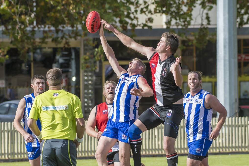 Inverell's Michael Gould comes over the back and looks to tap the ball to Gregg Falkenberg. Photo: Peter Hardin